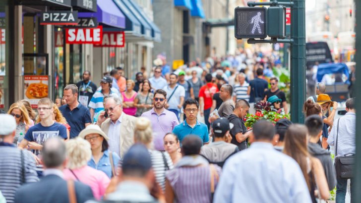 Crowded sidewalk on 5th Avenue with tourists and commuters on a sunny day