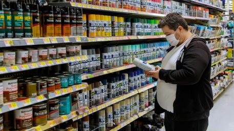 A man wearing a protective mask in buyer selects paint