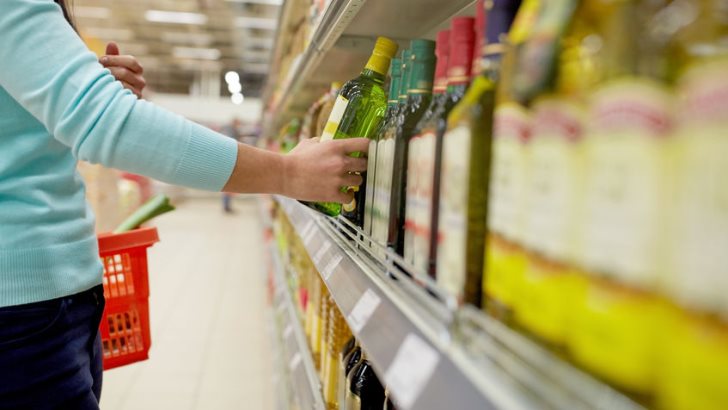 A woman buying olive oil at supermarket