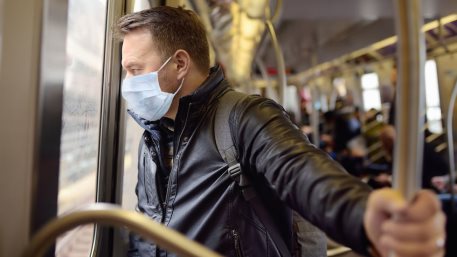 Mature man wearing disposable medical face mask in car of the subway in New York