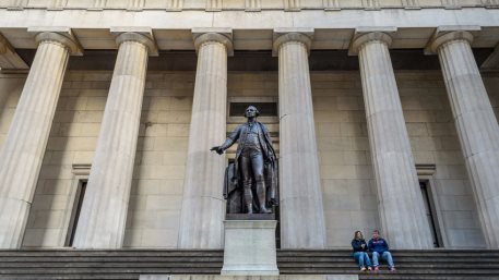 Couple Sitting in Front of the Federal Building in Wall Street