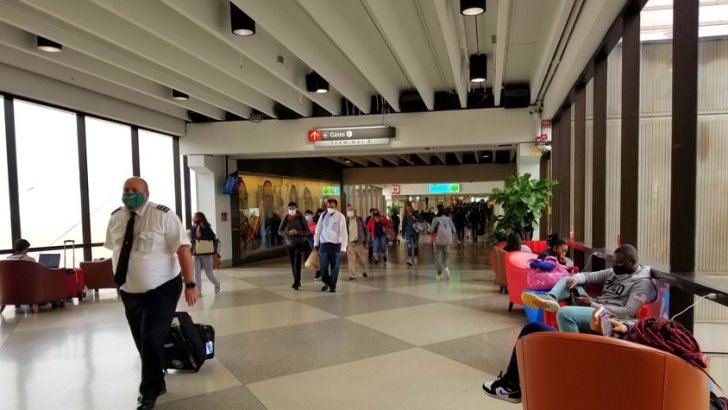 Passengers and workers wearing mask walking to their destination at the airport terminal