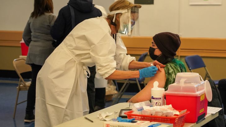 BROOKLYN, NEW YORK - JANUARY 19, 2021: A woman receives a dosage of the COVID-19 vaccine at Abraham Lincoln Hill School vaccination site in Brooklyn, New York