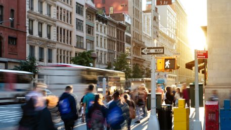 Crowds of people in motion walking down the busy sidewalk on 5th Avenue in Midtown Manhattan, New York City NYC